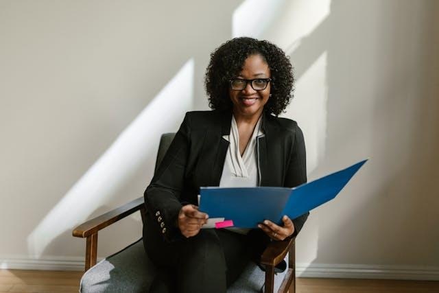 Person sitting in chair and holding folder